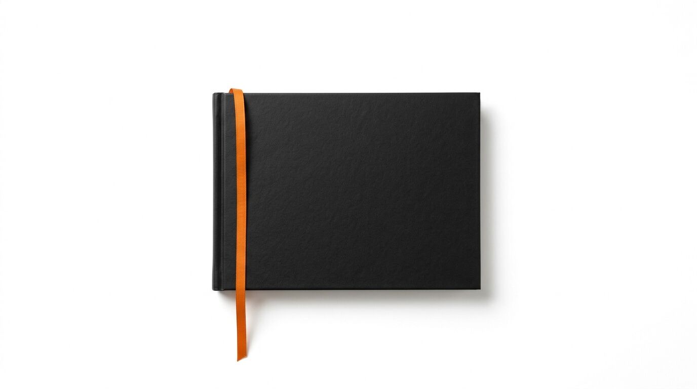Schwarzes Buch im Querformat mit orangefarbenem Leseband auf weißem Grund aus der Draufsicht