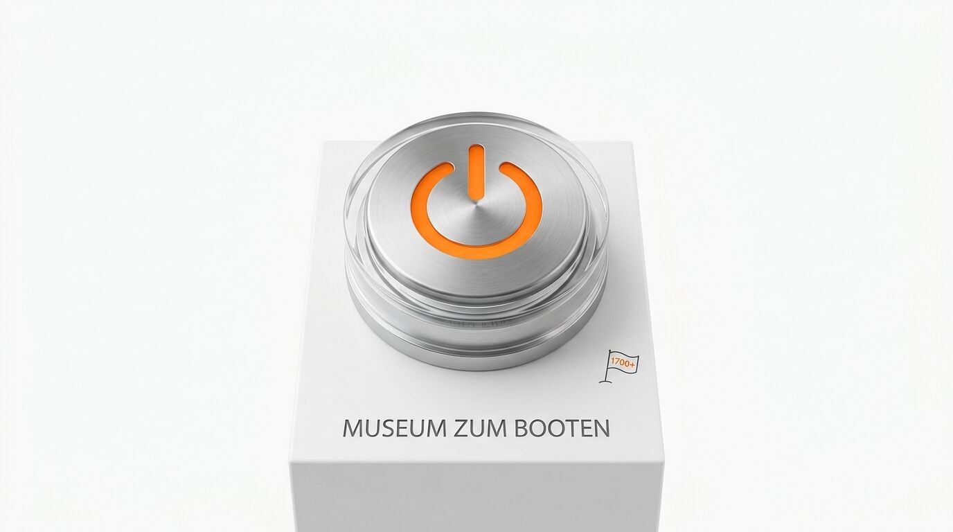 Runder Schalter aus Metall und Glas mit orangem Power-Symbol, beschriftet mit „MUSEUM ZUM BOOTEN“