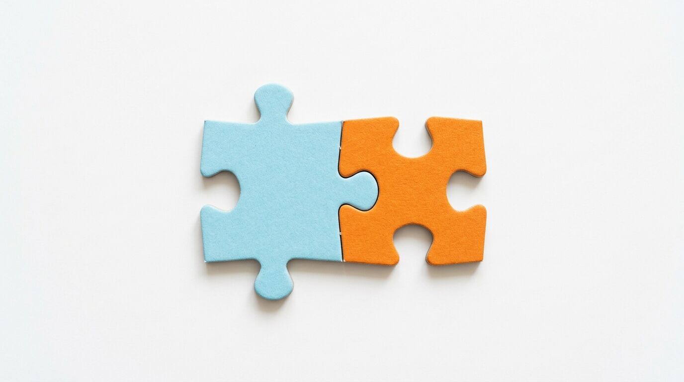 Zwei verbundene Puzzleteile, hellblau und orange, auf weißem Grund