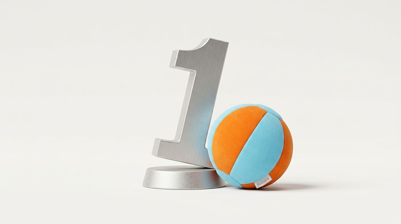 Metallerne Zahl Eins und ein weicher, orange-hellblauer Ball auf hellem Grund
