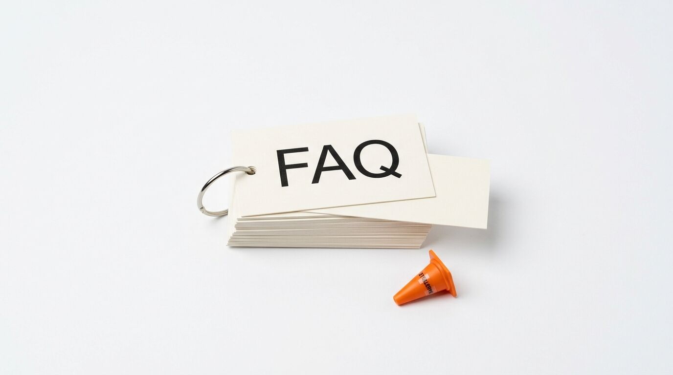 Karteikartenstapel mit Aufschrift FAQ und Ringbuchmechanismus, orangefarbener Pylon, weißer Grund