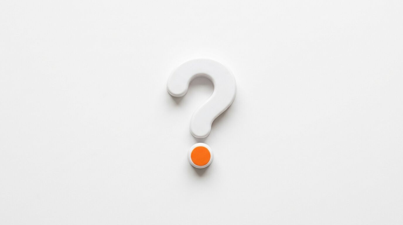Weißes Fragezeichen aus Kunststoff mit orangefarbenem Punkt auf weißem Grund