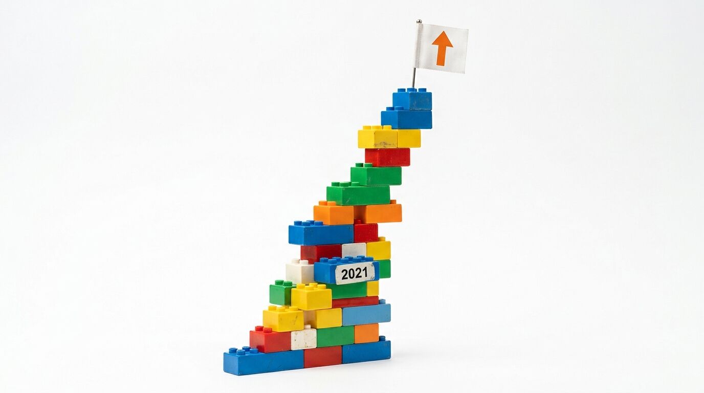 Ein steigender bunter Spielzeugstein-Turm mit „2021“ und Flagge oben