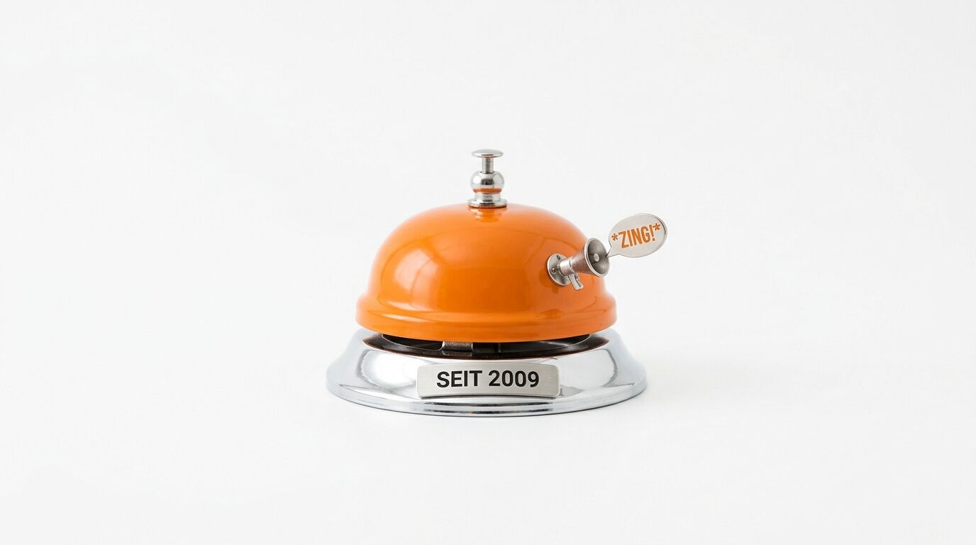 Eine orangefarbene Rezeptionsglocke mit eingravierter Plakette