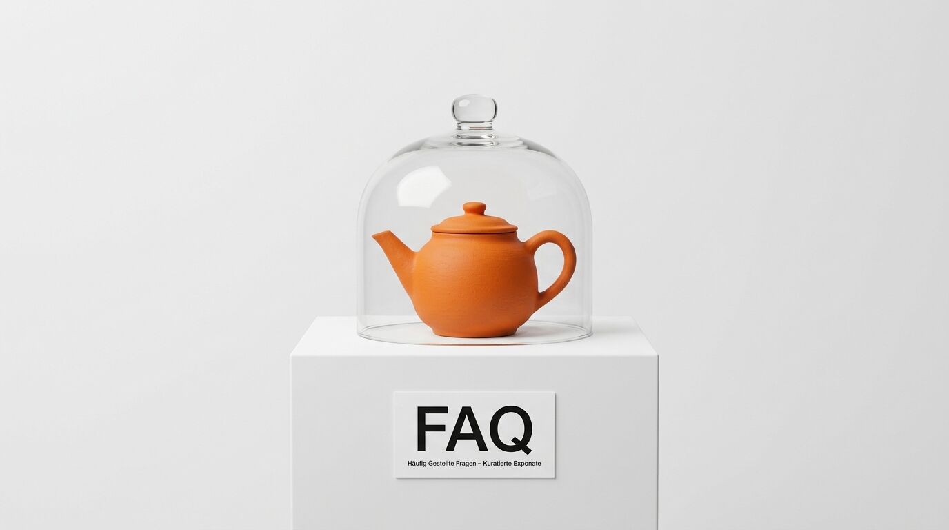 Teekanne unter Glasglocke auf Podest mit FAQ-Schild