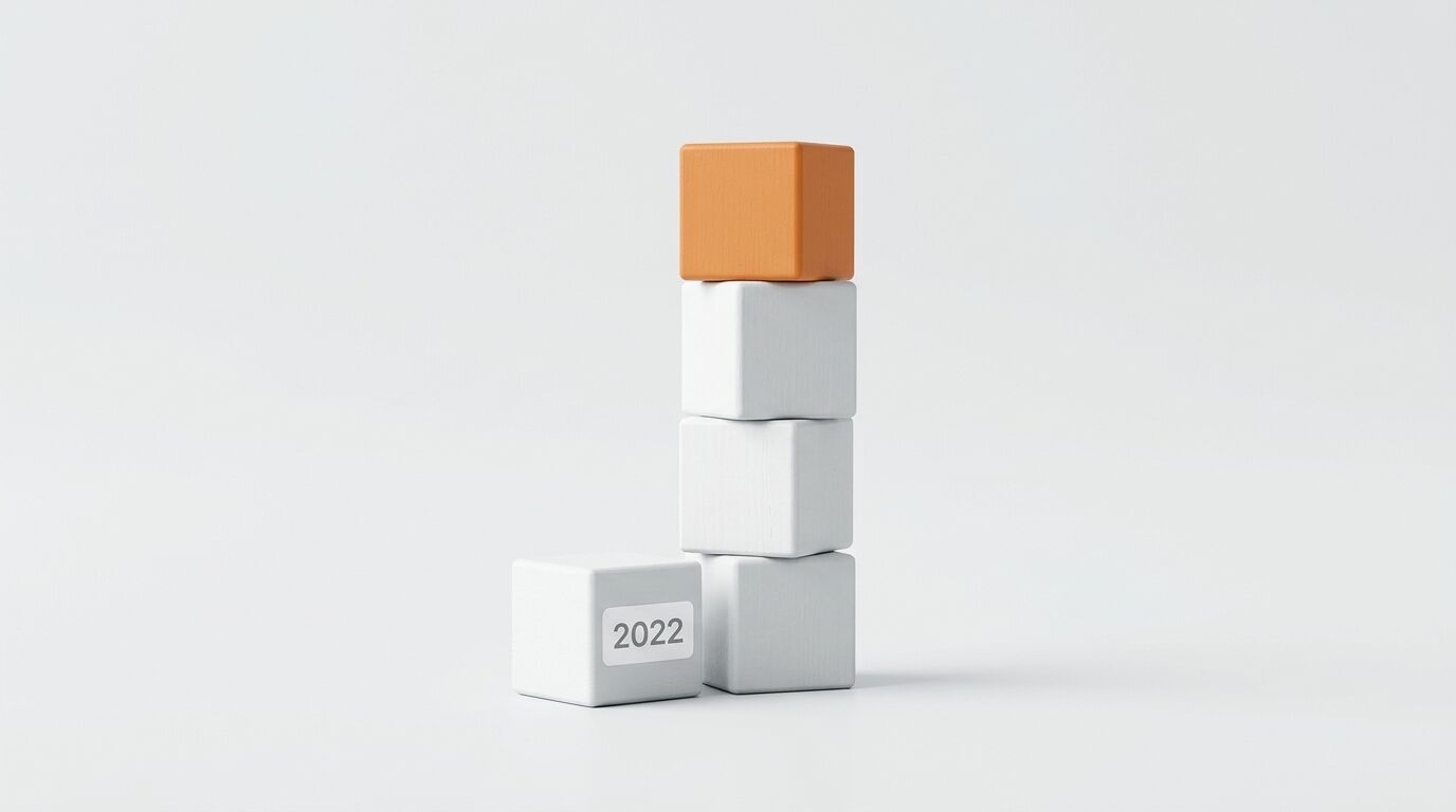 Ein Würfelstapel mit einem obersten orangefarbenen Würfel und einem Würfel mit der Aufschrift 2022 vor hellem Hintergrund
