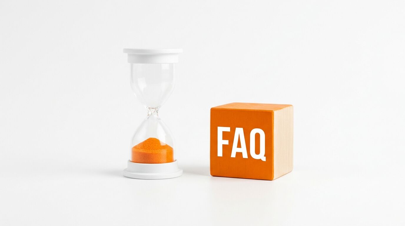 Eine Sanduhr mit oranger Füllung und ein orange-weißer Holzwürfel mit der Aufschrift „FAQ“ stehen auf einem weißen Tisch vor einem weißen Hintergrund