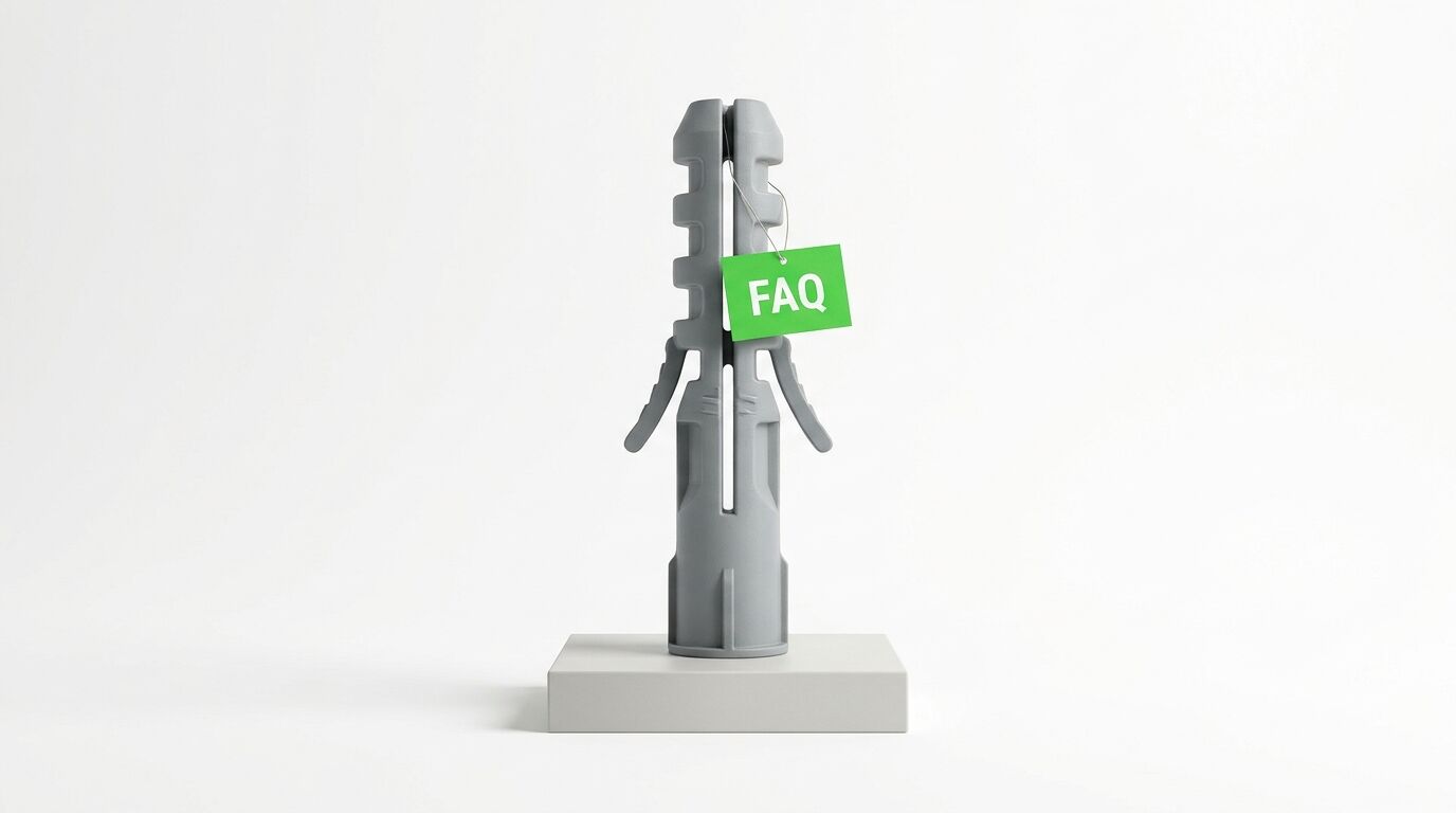 Großer grauer Dübel mit grünem „FAQ“-Schildchen auf weißem Podest